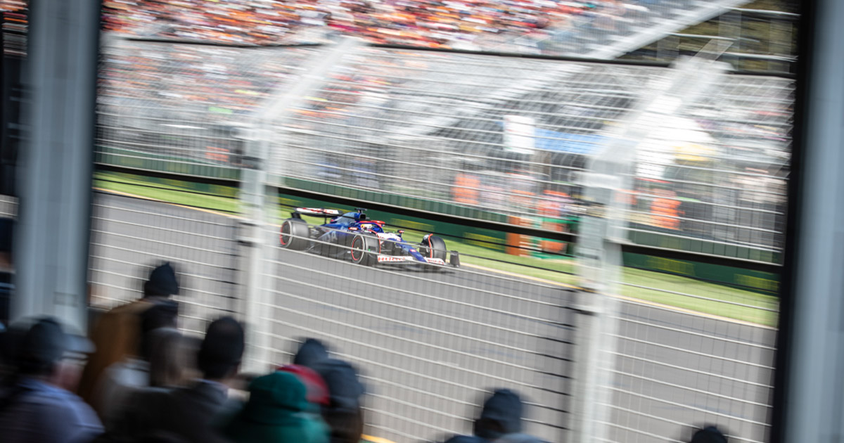 F1 cars race at the Australian Grand Prix as the crowd looks on