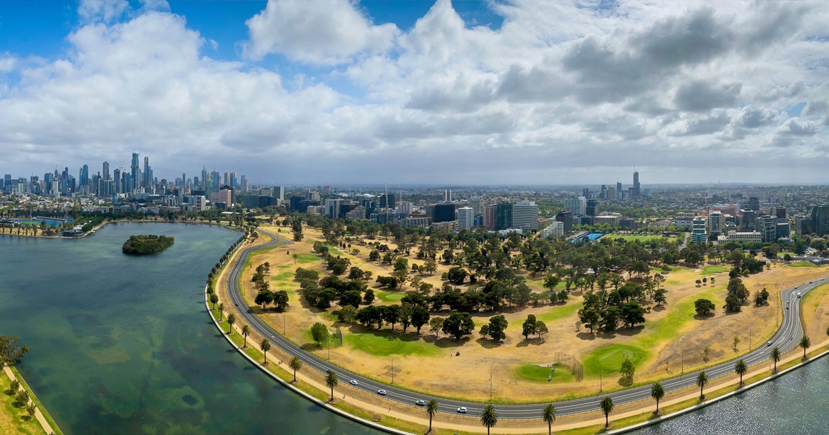 Track running through Albert Park with the Melbourne cityscape behind
