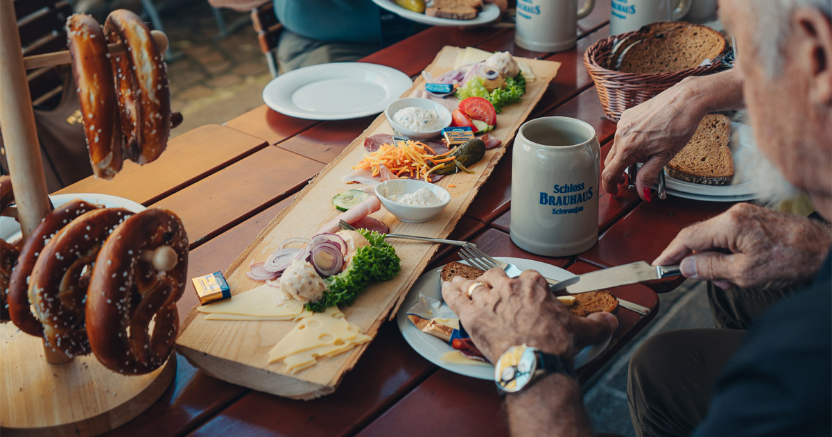 Beer, pretzels, meats and more: it must be Bavaria! A man dines on a platter of Bavarian cold cuts served with a stein of beer and pretzels