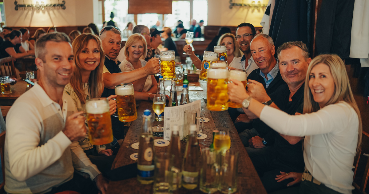 A happy group of HunterMoss guests toasting steins at Oktoberfest