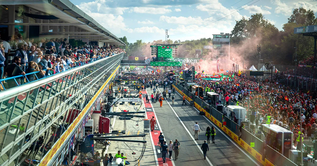 Red smoke rising above a large crowd on the track at Monza