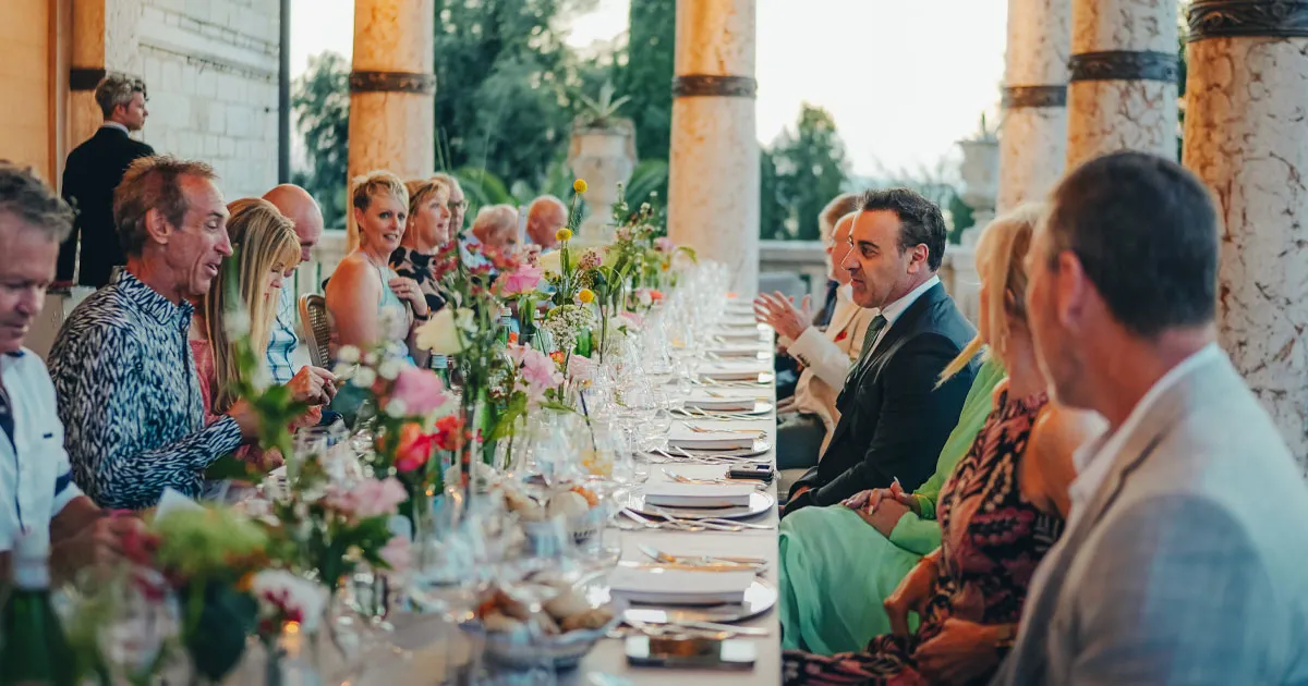 HunterMoss guests enjoying lunch at a long and elegant table in Italy