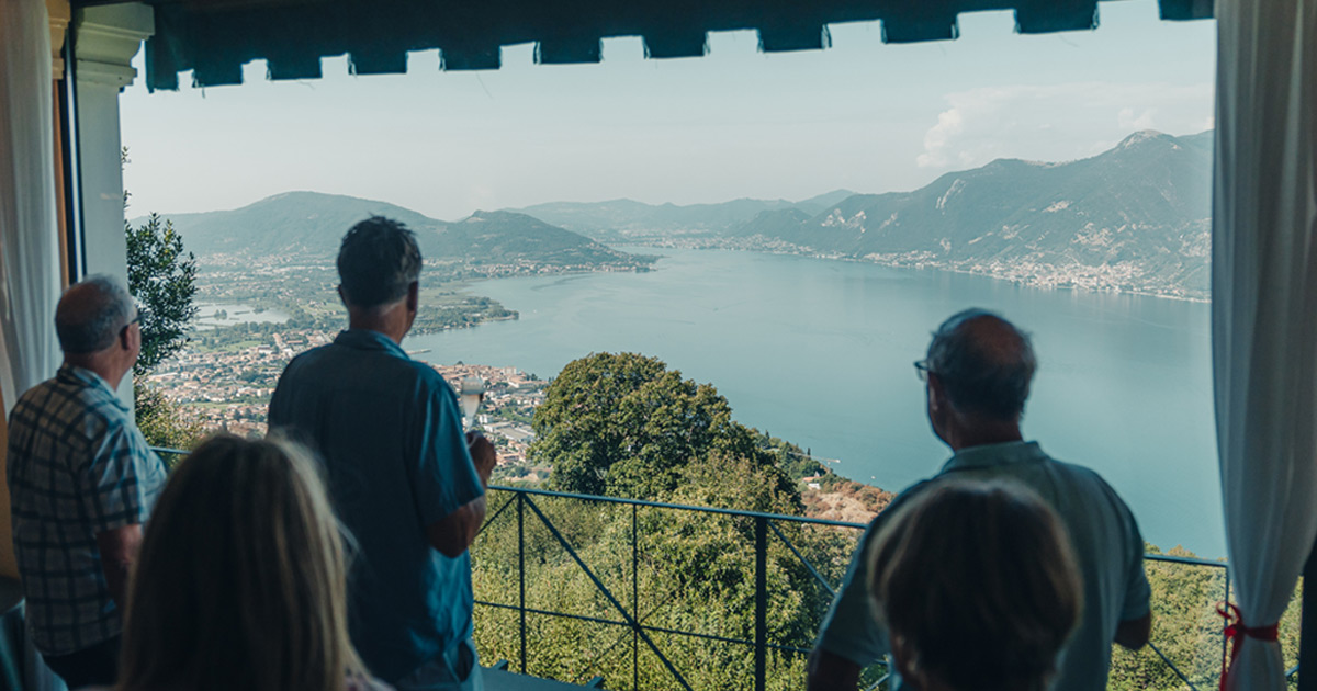 A small group admire the lake view from a raised balcony on a HunterMoss luxury tour