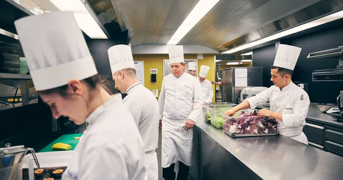 Chefs in traditional attire in the Locanda Barbarossa kitchen.