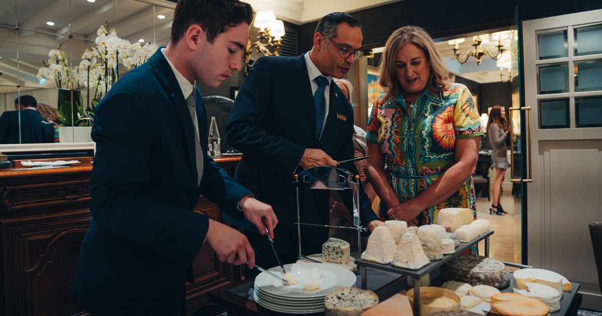 An HunterMoss guest inspects the cheese cart at an upscale European restaurant