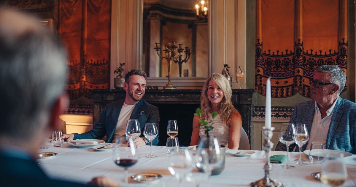 Anthony Moss of HunterMoss chatting with a small group at an elegant French restaurant