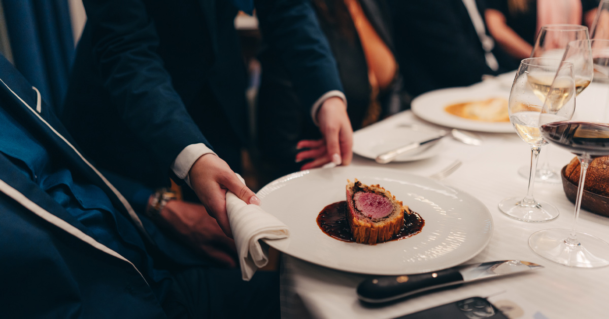 A finely plated beef Wellington with matching wine being carefully served to an HunterMoss guests