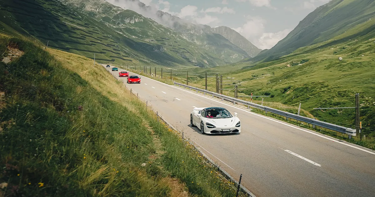 A convoy of HunterMoss supercars led by a white McLaren 720S