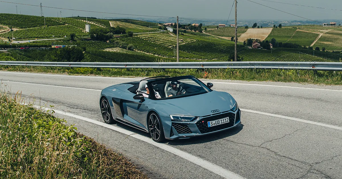A grey Audi R8 convertible being driven through rolling hills by HunterMoss guests.