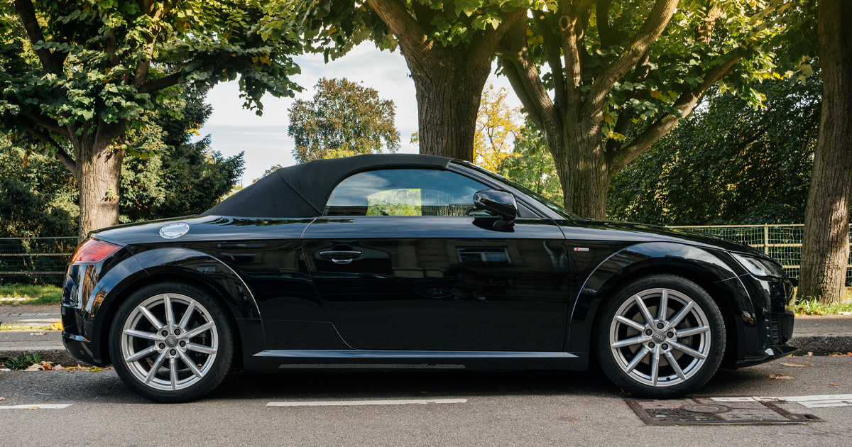 A black Audi TT cabriolet with black top