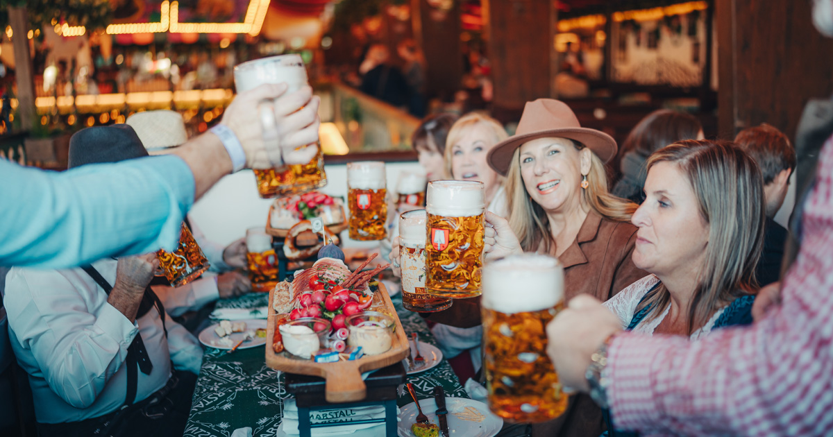 Happy tour guests toast frothy steins as part of a HunterMoss German supercar tour