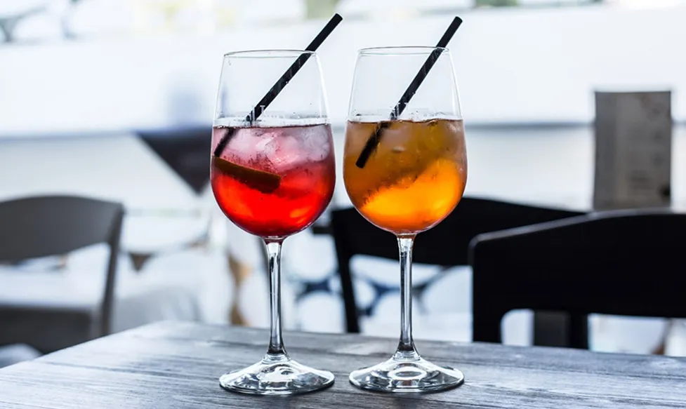 A pair of iced apertifs with straws sit on a table in Milan during an HunterMoss Italian driving holiday
