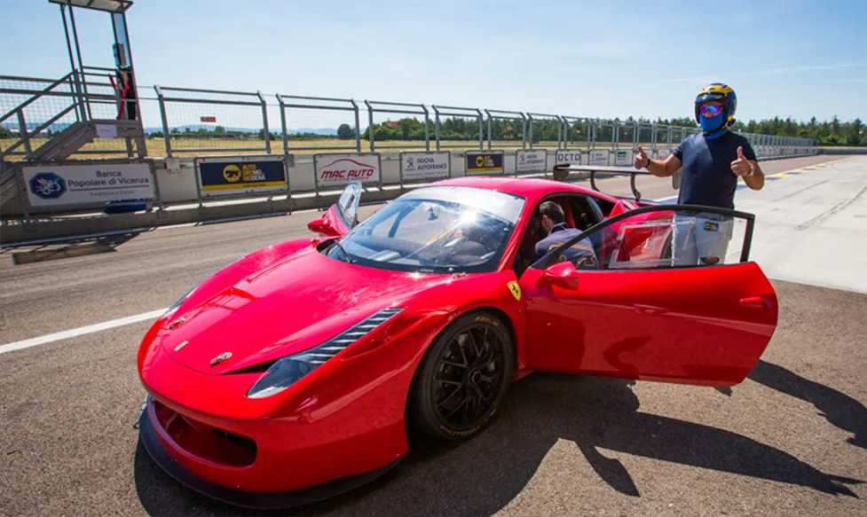 A track-ready red Ferrari is prepared to be driven round the Monza circuit by one of HunterMoss’ guests. He has two thumbs up.