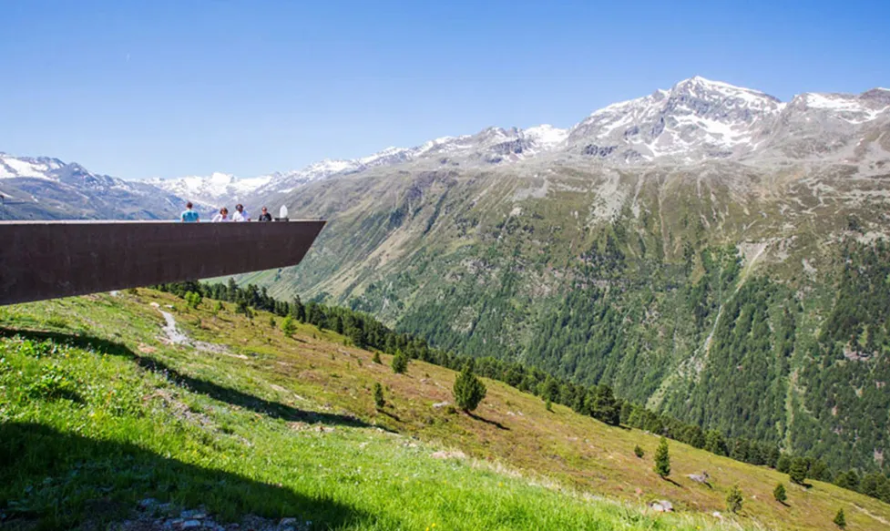 HunterMoss guests stand on a viewing station in the Italian Alps, overlooking a dramatic valley