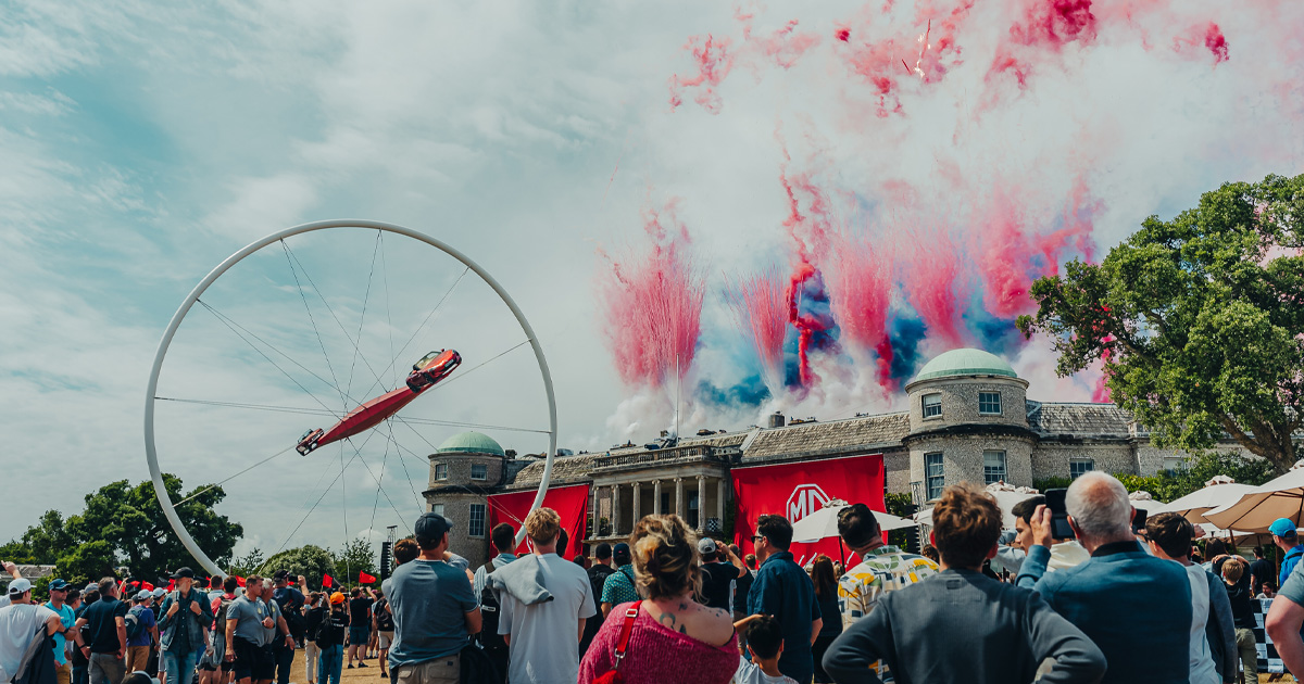 Goodwood House with colourful smoke display and ornate racing car sculpture