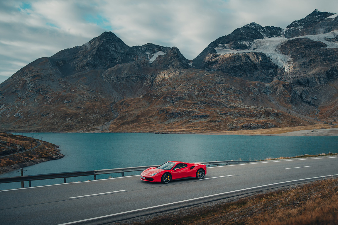 Red Ferrari driving in the Dolomites on a supercar driving tour of Italy