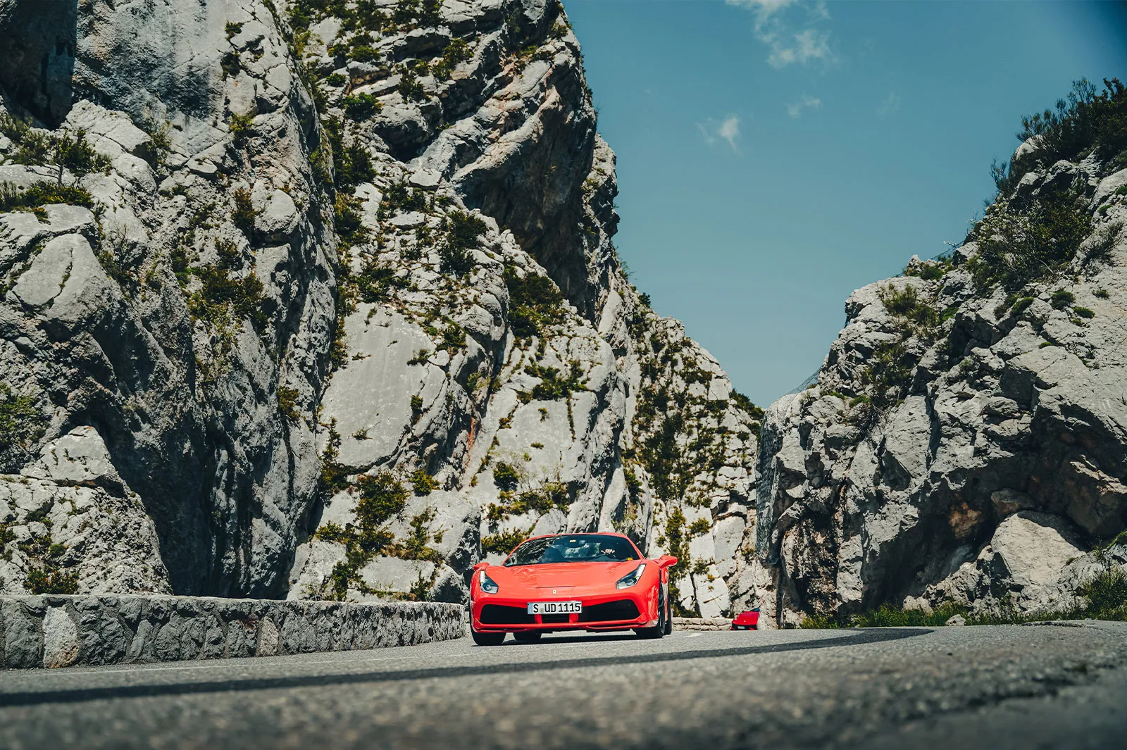 A red Ferrari carves through a steep rocky gully on an HunterMoss holiday