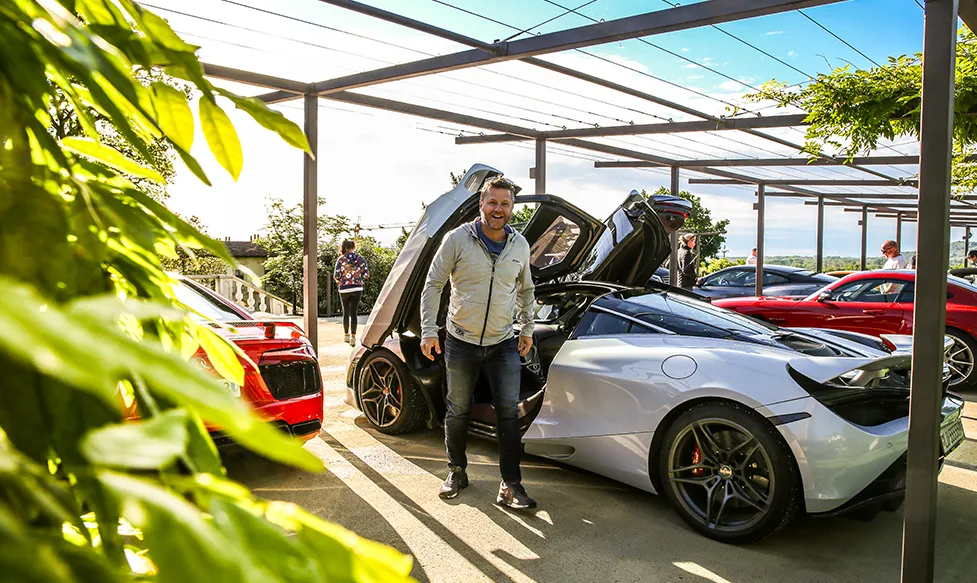 A man is filled with happiness as he exits a McLaren 720S on an HunterMoss dream car holiday.