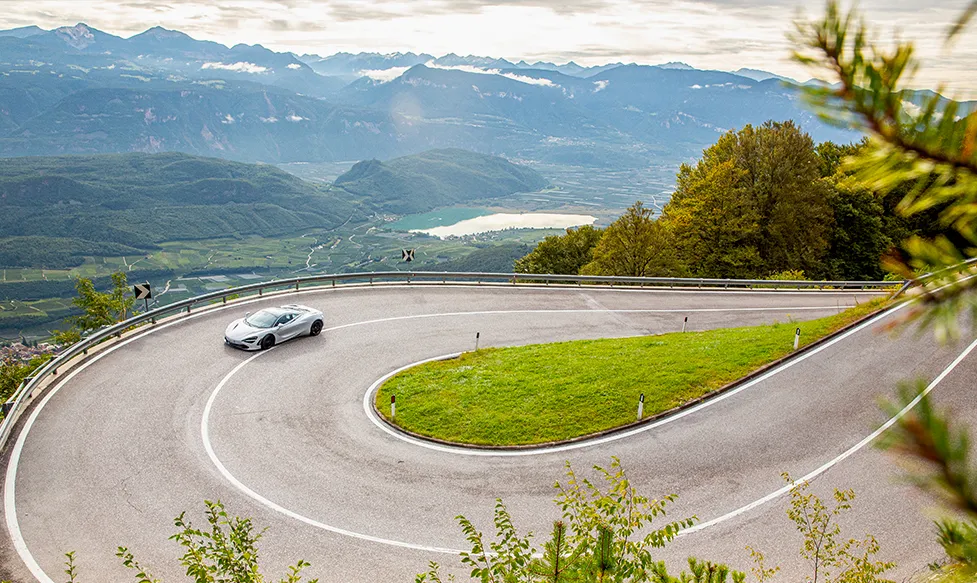A McLaren drives up a steep hill in the Tuscan countryside on an HunterMoss luxury tour of Tuscany