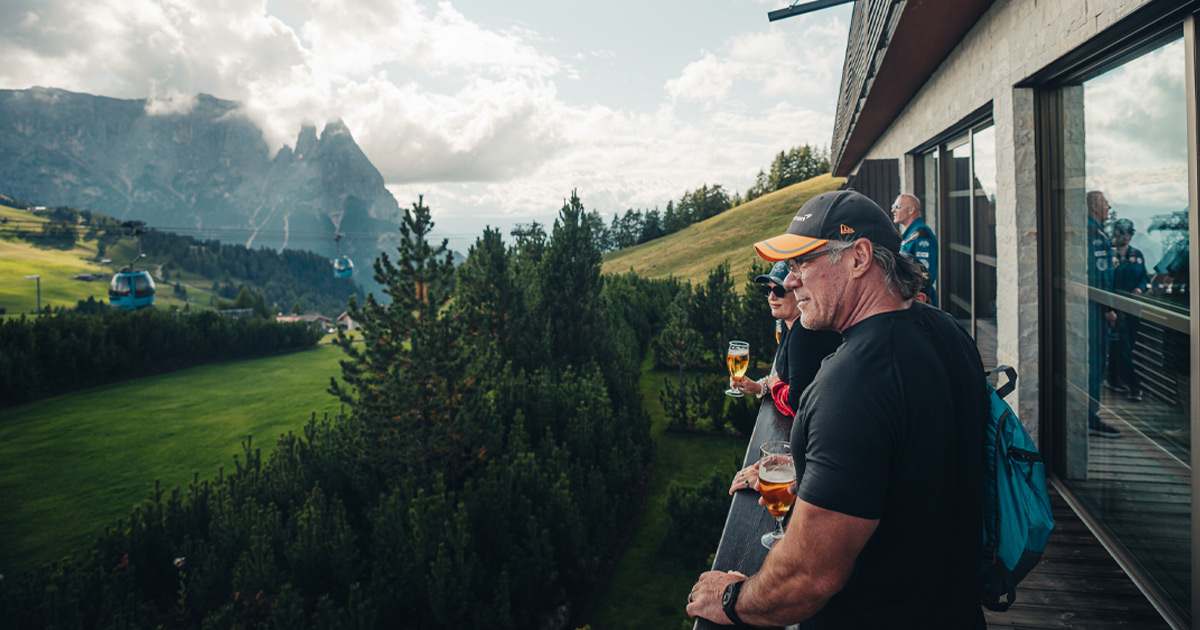 HunterMoss tour guests enjoying a beer on a balcony as they admire a spectacular view of mountains