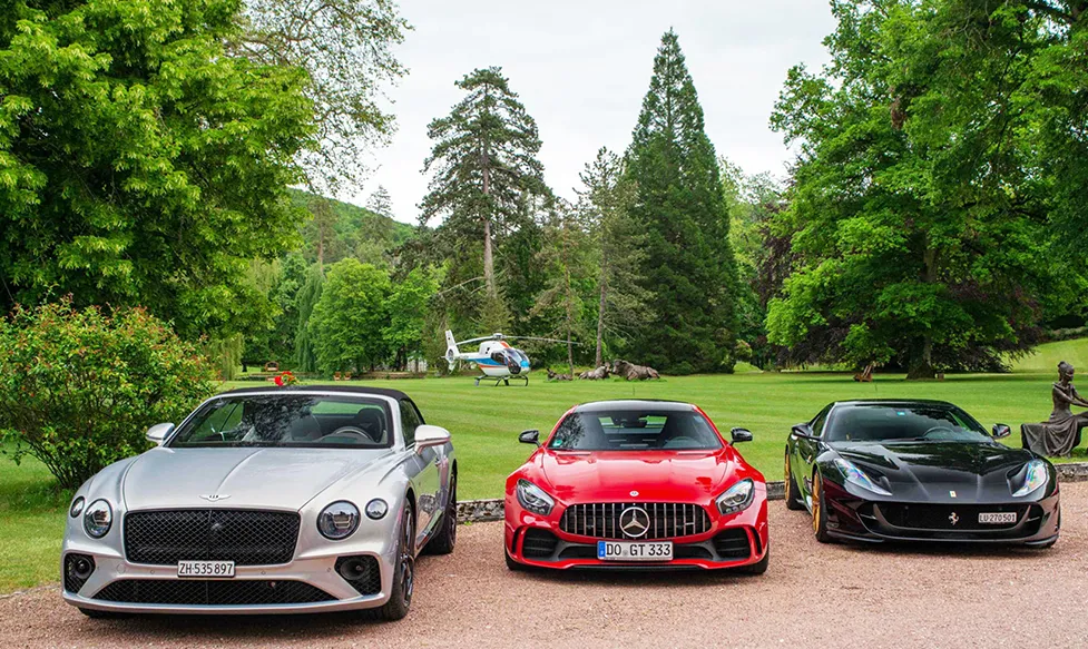 A Bentley, a Medcedes and a Ferrari parked side by side during HunterMoss European Supercar Tour