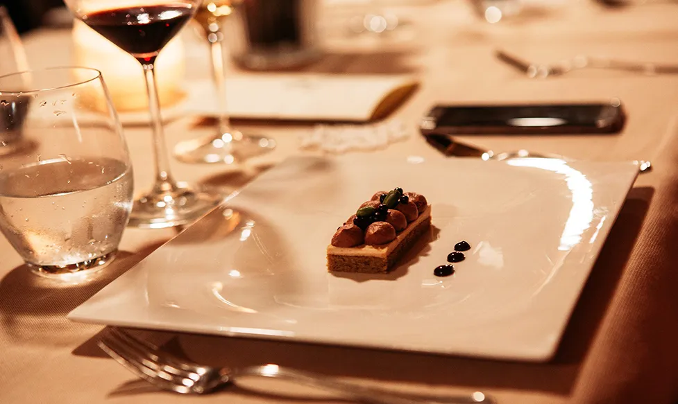 A delicate dessert sits on a plate during a meal on an HunterMoss supercar tour