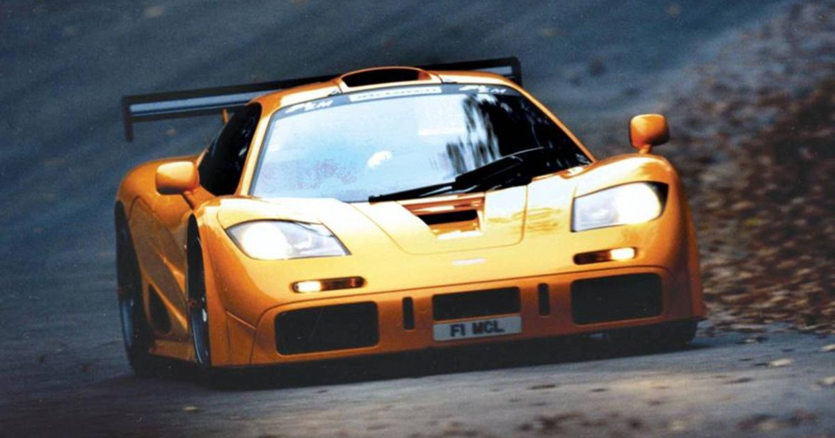 The GTR version of the F1 was even wilder and took its cues from the racing version. An orange McLaren F1 GTR with its headlights on as it is driven on a country road
