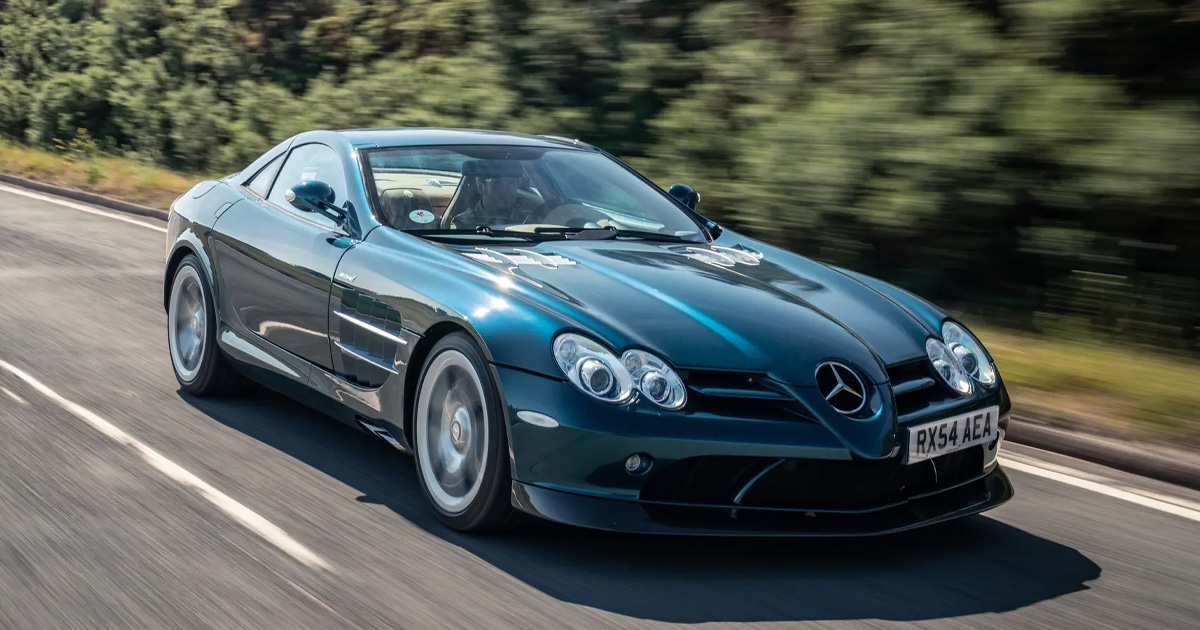 The SLR was a brawny, brainy beauty and hasn't aged a day. A teal McLaren-Mercedes AMG SLR supercar driving at pace on a country road.