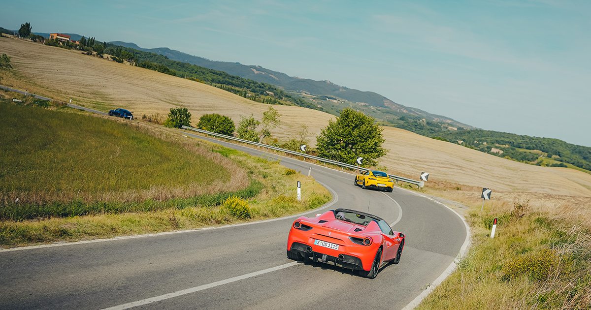 A red Ferrari 488 and yellow Mercedes-AMG GT on an HunterMoss journey.